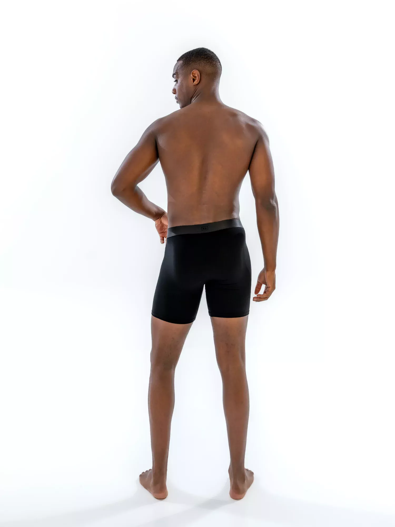 Model wearing the 6" Tonal Boxer Brief in black, back view
